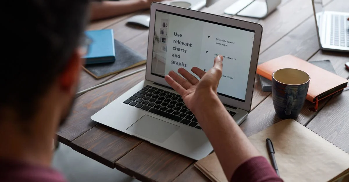 Une équipe collabore autour d'un ordinateur portable pour discuter du projet dans un bureau moderne.