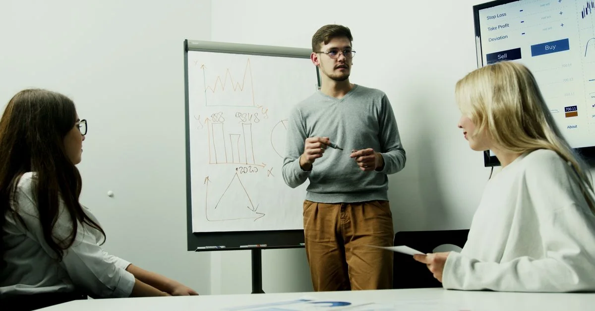 Des adultes discutant de graphiques financiers lors d'une session de travail en équipe.